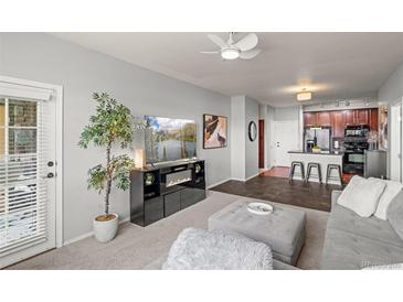 Cozy living room with modern furniture, stylish decor, and a view into the kitchen at 15460 Canyon Gulch Ln # 105, Englewood, CO 80112