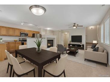 Bright, open living room features a fireplace, modern decor, and seamless flow to the dining area at 5255 Memphis St # 1009, Denver, CO 80239