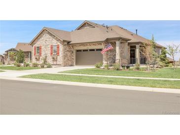 Charming single-Gathering home featuring a stone facade, two-car garage, and well-manicured front yard at 25059 E Alder Dr, Aurora, CO 80016