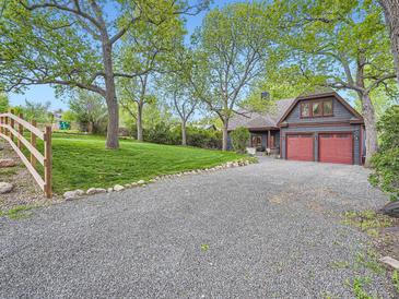 Charming home with a spacious driveway, lush lawn, mature trees, and a two-car garage at 845 Urban St, Lakewood, CO 80401