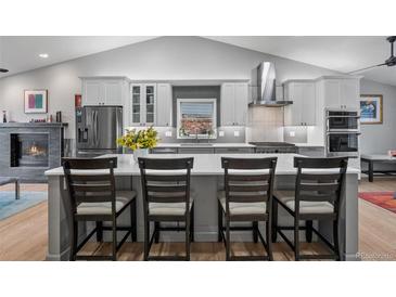 Modern kitchen with a large island, stainless steel appliances, and open floor plan at 2687 E 124Th Pl, Thornton, CO 80241
