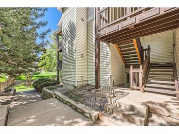 A view of a home's wood-sided exterior with stairs leading up to a balcony at 17381 E Mansfield Ave # 711L, Aurora, CO 80013