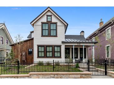Charming two-story home featuring white siding, black-trimmed windows, and a quaint front porch at 208 N Ridge St, Breckenridge, CO 80424