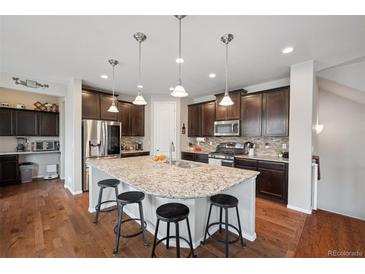 Gourmet kitchen boasts an island, stainless steel appliances, and dark wood cabinetry at 19760 W 59Th Dr, Golden, CO 80403