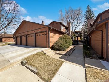 Exterior view of a brown townhome featuring an attached three-car garage and well-maintained landscaping at 9484 W 89Th Cir, Broomfield, CO 80021