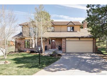 Charming two-story home featuring a brick facade, a spacious garage, and a well-maintained front yard at 8687 N Pinery Pkwy, Parker, CO 80134