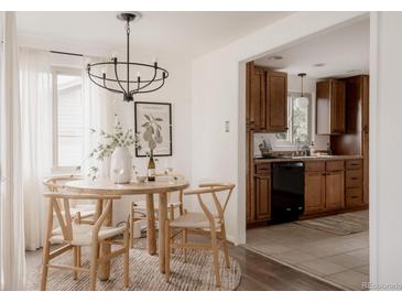 Bright dining area features wood table and chairs, modern lighting, and view into the kitchen at 916 Florence St, Aurora, CO 80010