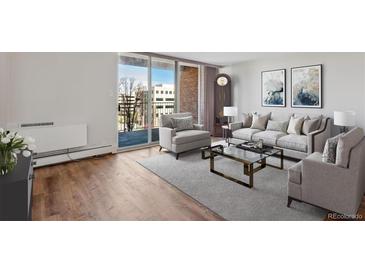 Sunlit living room features stylish furniture, wood floors, a neutral rug, and sliding doors to the balcony at 955 Eudora St # 505E, Denver, CO 80220