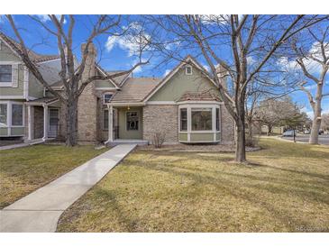 Charming brick home featuring a well-manicured front yard with mature trees at 11247 Wyandot St, Denver, CO 80234
