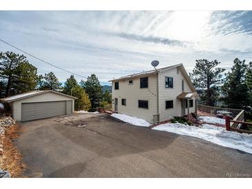 House exterior showcasing a two-story home, detached garage, and driveway at 9189 Fallen Rock Rd, Conifer, CO 80433