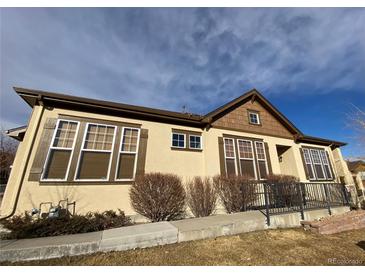 Inviting single-story home featuring beautiful earth-tone stucco, wood shutters, and well-maintained landscaping at 11925 W Ida Dr, Littleton, CO 80127