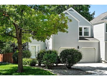 Charming two-story home with a well-maintained lawn, mature tree, and a two car garage at 6401 S Forest St, Centennial, CO 80121