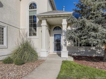 Two-story house with a beige exterior, attached garage, and landscaping at 370 Terra Vista St, Brighton, CO 80601