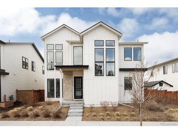 Striking modern farmhouse with white siding, black trim, and large windows creates a bold and inviting curb appeal at 5985 Galena St, Denver, CO 80238