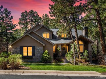 Charming home with stone accents, well-manicured lawn, and mature trees in a peaceful neighborhood at 484 Hyland Dr, Castle Rock, CO 80108