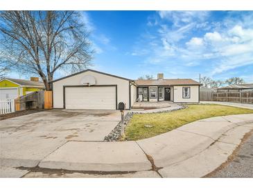 Ranch style home with attached garage, deck, and landscaped yard at 4360 E 70Th Ct, Commerce City, CO 80022