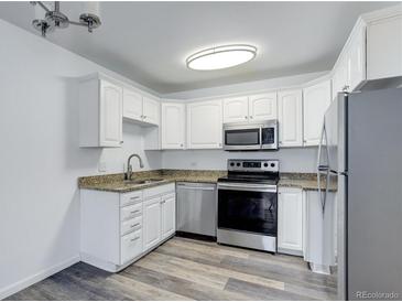 Well-lit kitchen featuring white cabinets, stainless steel appliances, and granite countertops at 755 S Alton Way # 9D, Denver, CO 80247