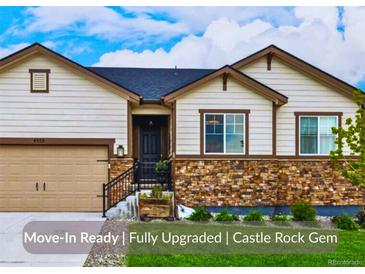 Charming single-Gathering home with a stone facade, manicured lawn, and an attached two-car garage at 4555 Gray Wolf Ln, Castle Rock, CO 80104
