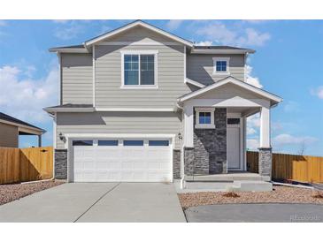 Charming two-story home featuring a two car garage and stone facade elements at 17962 E 94Th Pl, Commerce City, CO 80022