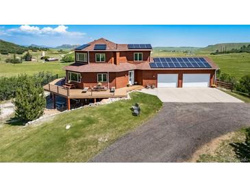Stunning two-story home boasts solar panels and a spacious deck perfect for outdoor entertaining at 4586 Best Rd, Larkspur, CO 80118