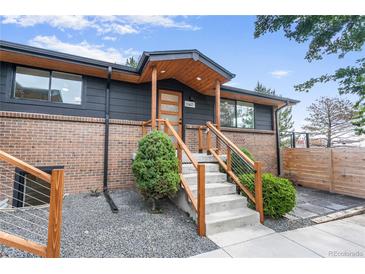 Inviting front entrance with modern wood accents and stylish stair railing at 2067 Depew St, Edgewater, CO 80214