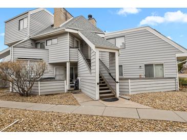 View of the exterior featuring light gray siding, stone accents, and a stairway leading to the entrance at 17034 E Tennessee Dr # 105, Aurora, CO 80017