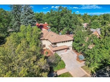 Luxury home with spacious driveway, surrounded by lush trees at 5635 E 17Th Avenue Pkwy, Denver, CO 80220