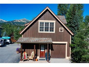 Charming cabin-style home featuring a wood exterior, cozy porch, and stunning mountain views at 302 N Main St, Breckenridge, CO 80424