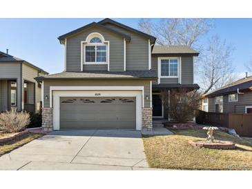 Charming two-story home featuring an attached two car garage and landscaped front yard at 10174 Spotted Owl Ave, Highlands Ranch, CO 80129