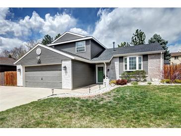 Charming two-story home with a manicured lawn, brick accents, and a well-maintained gray siding at 8581 W Hinsdale Pl, Littleton, CO 80128