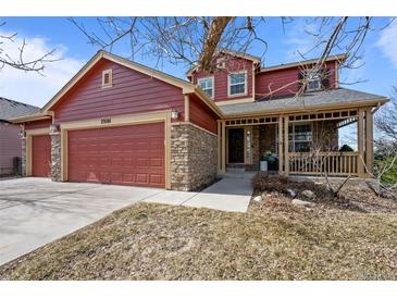 Charming two-story home with a welcoming front porch and a three-car garage in a residential neighborhood at 23101 Timber Spring Ln, Parker, CO 80138