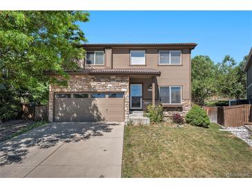 Charming two-story home featuring stone accents, a well-manicured lawn, and attached two car garage at 4697 Waldenwood Dr, Highlands Ranch, CO 80130