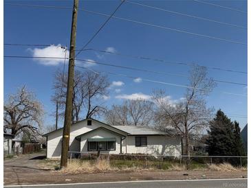 Charming single-story home featuring a classic design and a well-maintained yard, framed by a clear blue sky at 7750 Indiana St, Arvada, CO 80007