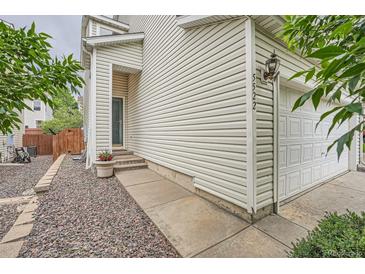 Two story home with vinyl siding, walkway, and attached two car garage at 5522 S Quemoy Cir, Aurora, CO 80015