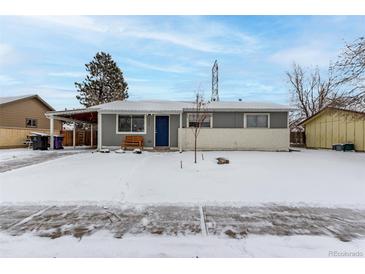 Ranch style home with gray siding, snowy yard, and covered carport at 5332 Granby St, Denver, CO 80239