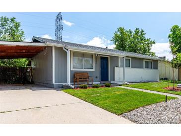 Charming single-story home with a blue front door, well-maintained lawn, and a covered parking area at 5332 Granby St, Denver, CO 80239