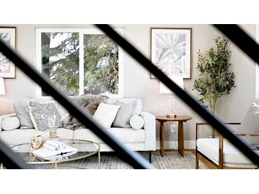 Cozy living room featuring a stylish sofa, decorative pillows, and a large window offering natural light at 2890 S Sherman St, Englewood, CO 80113