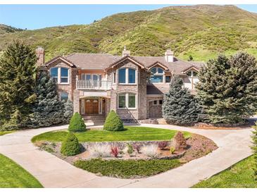 Stunning stone home with a manicured lawn, mature trees and an attractive circular drive at 27 Tamarade Dr, Littleton, CO 80127