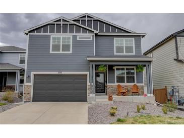 Charming two-story home with a modern gray exterior, a covered porch, and a two car garage at 635 Silver Rock Trl, Castle Rock, CO 80104