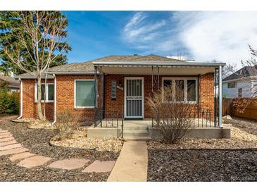 Charming brick home featuring a covered front porch and well-maintained landscaping at 1386 S Garfield St, Denver, CO 80210