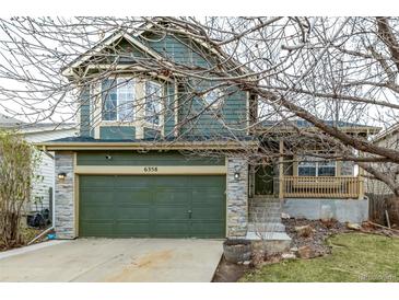 Charming two-story home featuring a stone-accented garage and welcoming front porch at 6358 E 121St Pl, Brighton, CO 80602