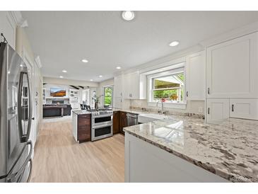 Modern kitchen featuring granite counters, stainless steel appliances, and white cabinetry at 2974 E Otero Cir, Centennial, CO 80122