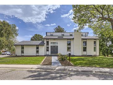 Charming two-story home with modern architecture, manicured lawn, and brick chimney at 7792 Garrison Ct, Arvada, CO 80005