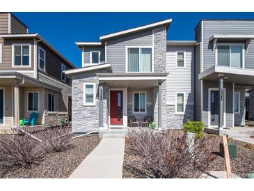 Charming gray two-story home featuring stone accents and a red front door at 23584 E 5Th Pl, Aurora, CO 80018