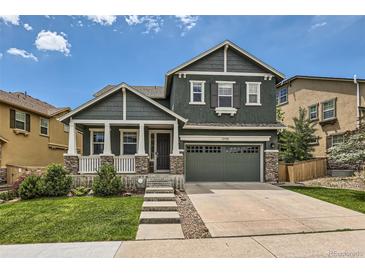 Charming two-story home boasts a well-maintained lawn and a welcoming front porch with stone accents at 10935 Valleybrook Cir, Highlands Ranch, CO 80130