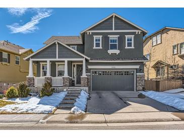 Charming two-story home with stone accents, covered porch, and attached two-car garage at 10935 Valleybrook Cir, Highlands Ranch, CO 80130
