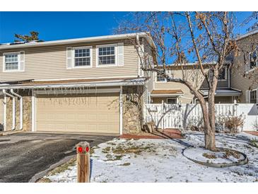 Tan siding townhouse with attached garage and small front yard at 3242 S Heather Gardens Way, Aurora, CO 80014