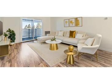 Bright living room featuring modern furniture, a balcony, and wood-look laminate flooring at 735 S Clinton St # 5B, Denver, CO 80247