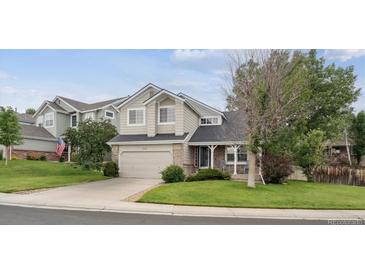 Charming two-story home featuring manicured lawn, stone accents, and a two-car garage at 20304 Vista Cir, Parker, CO 80138