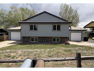 Split-level home featuring a front yard and a two-car garage on each side at 8832 Lipan St, Thornton, CO 80260